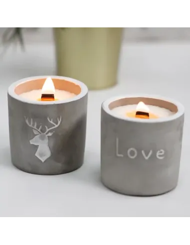 conjunto de 2 velas de hormigón redondas con mecha de madera encendidas