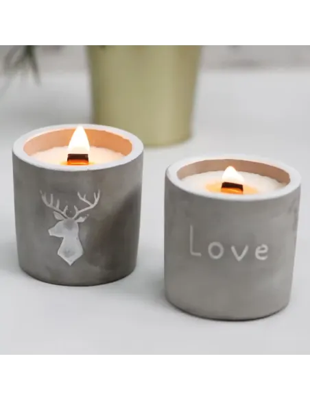 conjunto de 2 velas de hormigón redondas con mecha de madera encendidas