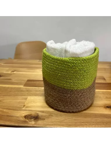 Detalle cesta verde y marrón con toallas dentro