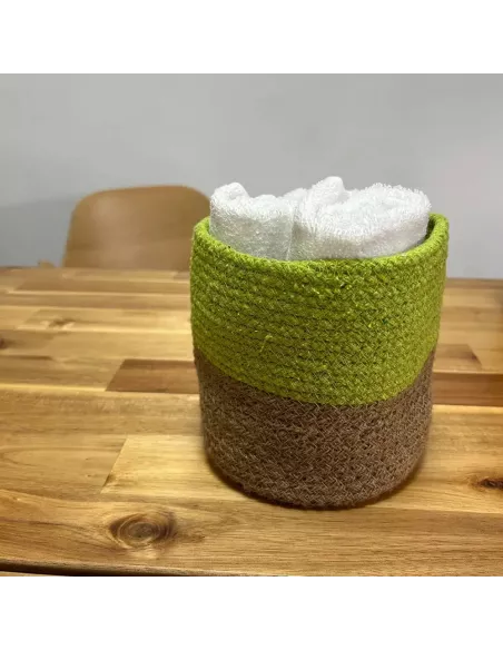 Detalle cesta verde y marrón con toallas dentro