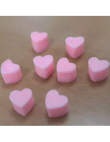 Corazones de cera de soja anaranjados sobre madera
