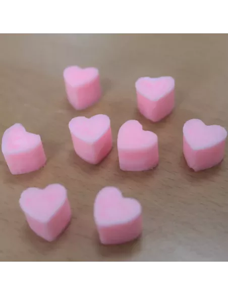 Corazones de cera de soja anaranjados sobre madera
