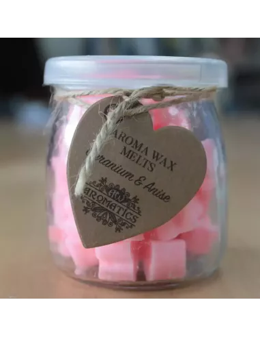 Frasco de cristal con ceras de soja en corazones anaranjados sobre madera