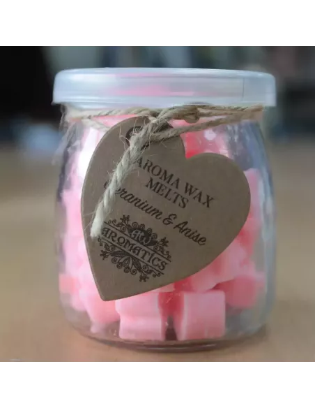 Frasco de cristal con ceras de soja en corazones anaranjados sobre madera