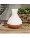 Difusor de aromas color nácar con base de madera y forma de jarrón con cambio de color y temporizador sobre un mueble de madera